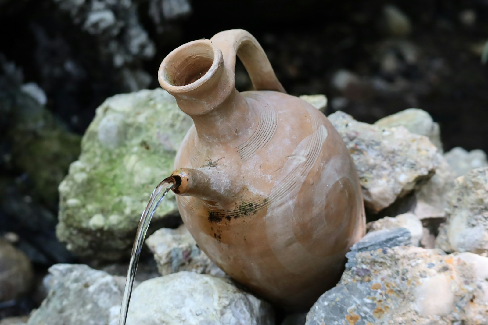 Photo by Zephan Buckley-Ryan a clay jug sitting on top of a pile of rocks